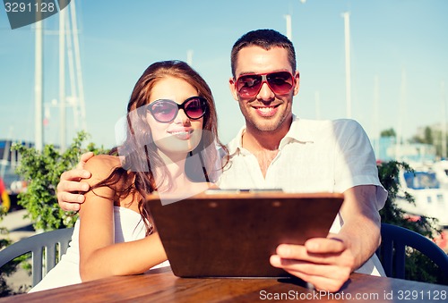 Image of smiling couple with menu at cafe