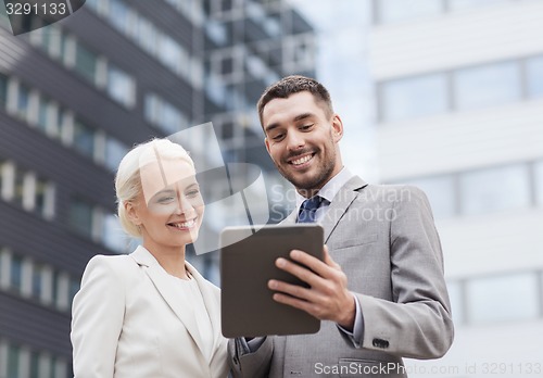 Image of smiling businessmen with tablet pc outdoors