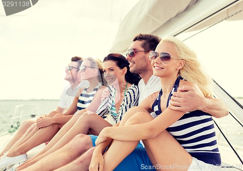 Image of smiling friends sitting on yacht deck