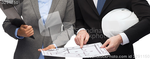 Image of businesspeople with blueprint and helmet