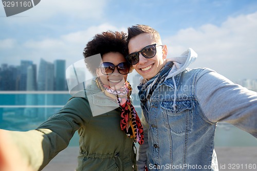 Image of happy teenage couple taking selfie in singapore