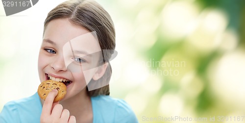 Image of smiling little girl eating cookie or biscuit