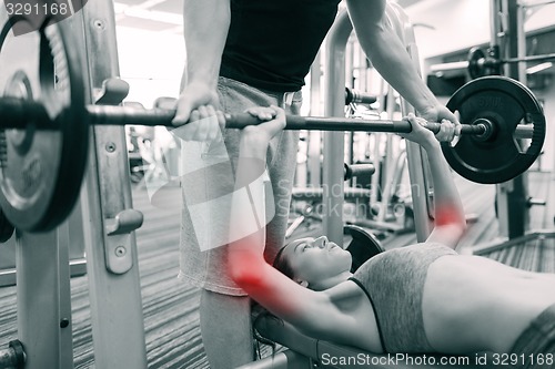 Image of man and woman with barbell flexing muscles in gym