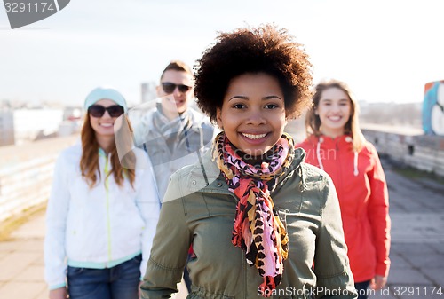 Image of group of happy teenage friends on city street