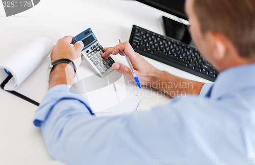 Image of businessman with notebook and calculator