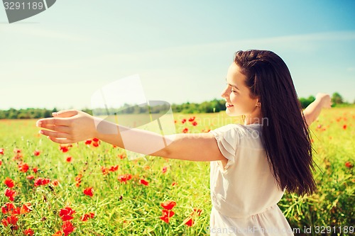 Image of smiling young woman on poppy field