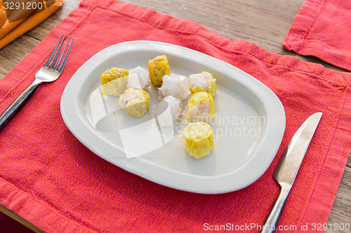 Image of plate of spring rolls with rice on table