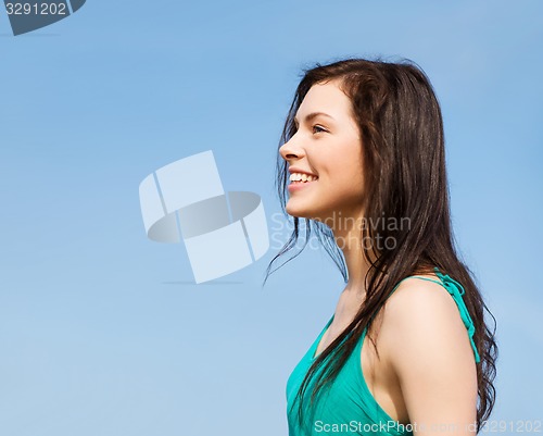 Image of beautiful girl over blue sky