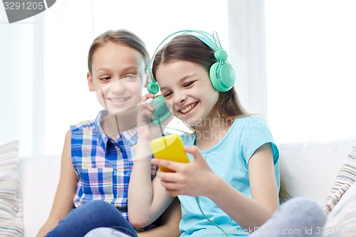 Image of happy girls with smartphone and headphones