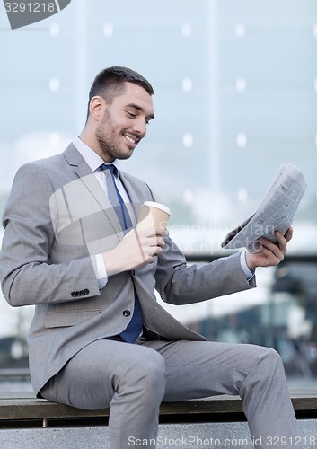 Image of young businessman with coffee and newspaper