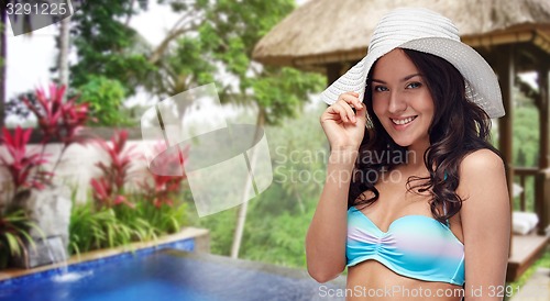 Image of happy young woman in bikini swimsuit and sun hat