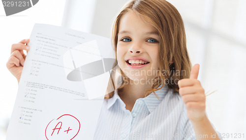 Image of smiling little student girl with test and A grade