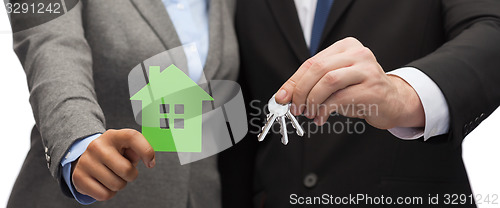 Image of businessman and businesswoman holding green house