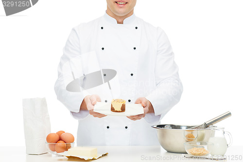 Image of close up of happy male chef cook baking dessert 