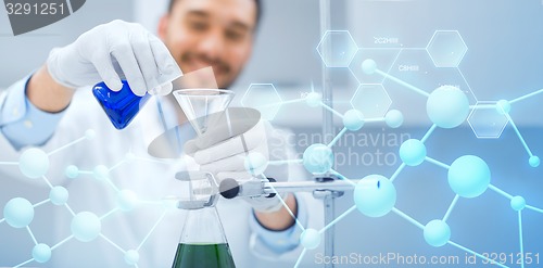 Image of close up of scientist with test tubes and funnel