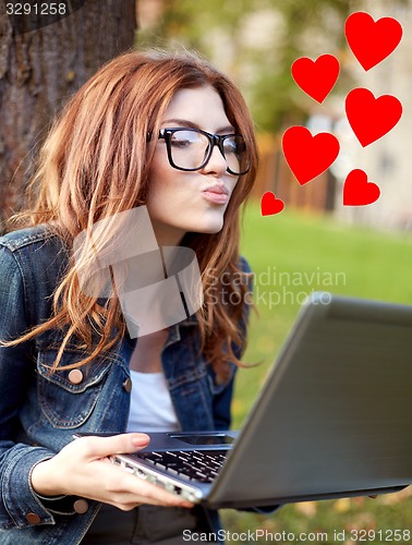 Image of happy student girl writing to notebook at campus