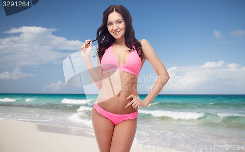 Image of happy young woman in pink bikini swimsuit