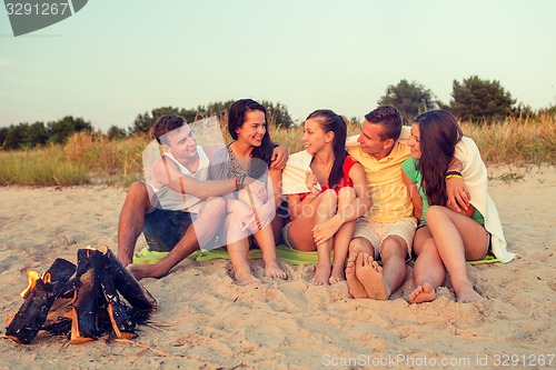 Image of smiling friends in sunglasses on summer beach
