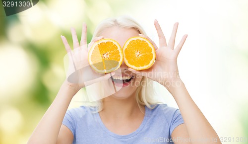 Image of happy woman having fun covering eyes with orange