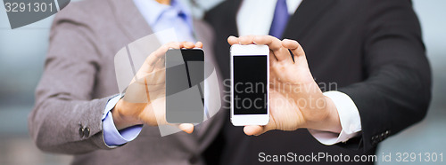 Image of businessman and businesswoman with smartphones