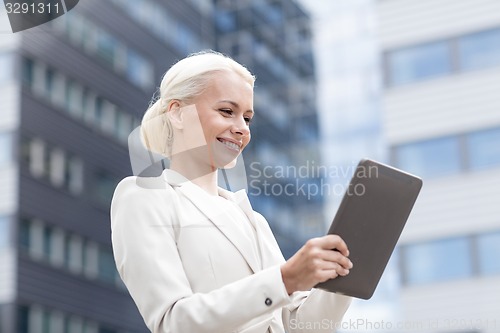 Image of smiling businesswoman with tablet pc outdoors