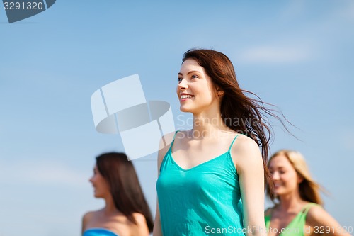 Image of girl with friends walking on the beach