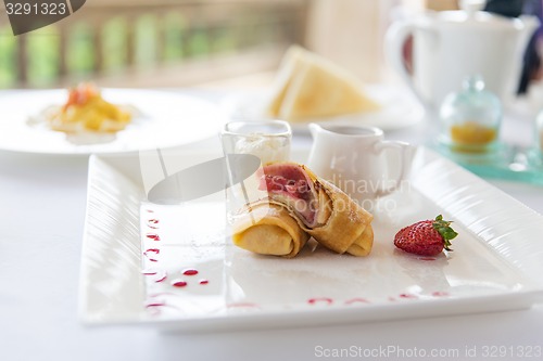 Image of close up of pancakes and honey or jam on plate