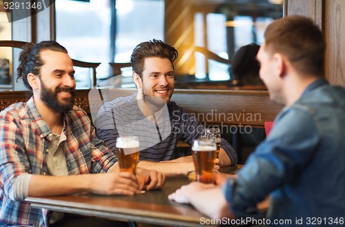 Image of happy male friends drinking beer at bar or pub