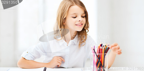 Image of girl drawing with pencils at school