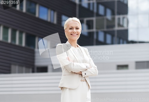 Image of young smiling businesswoman with crossed arms