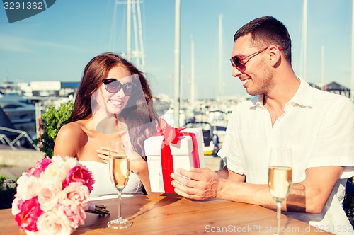 Image of smiling couple with gift box cafe