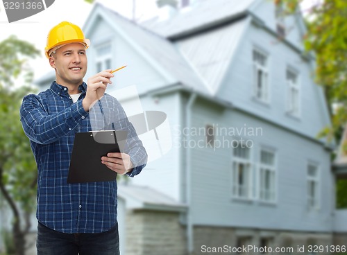 Image of smiling male builder in helmet with clipboard