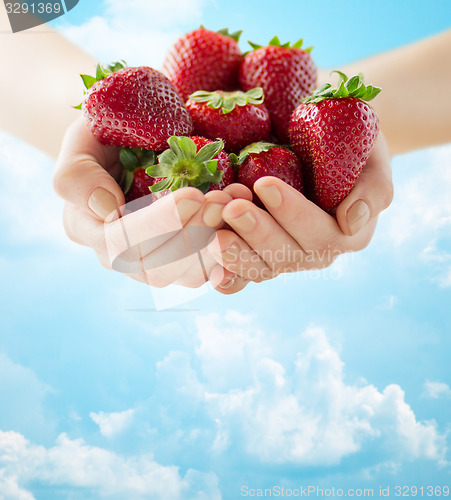 Image of close up of woman hands holding strawberries