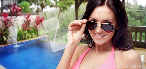 Image of happy woman in sunglasses and swimsuit