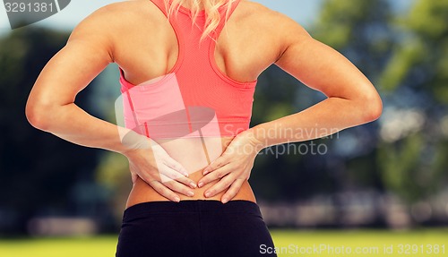 Image of close up of sporty woman touching her back