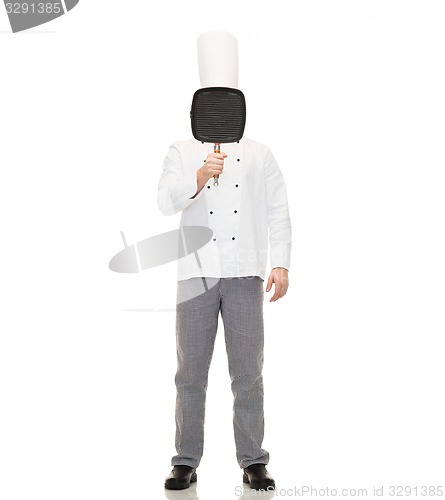 Image of male chef cook covering face with grill pan