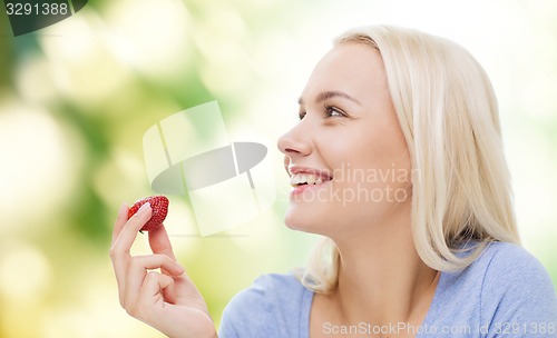 Image of happy woman eating strawberry