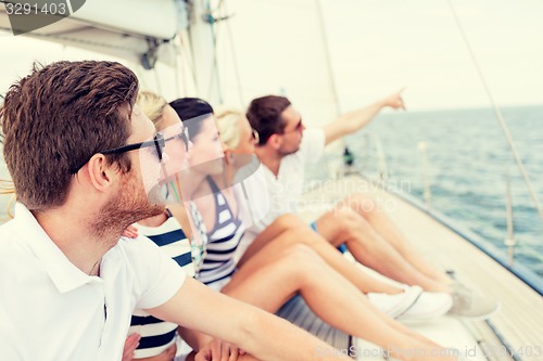 Image of smiling friends sitting on yacht deck