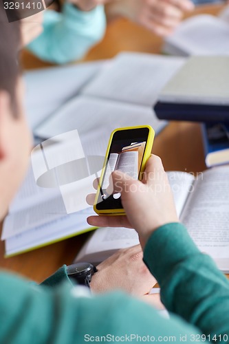 Image of student hands with smartphone making cheat sheet