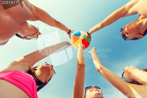 Image of smiling friends in circle on summer beach