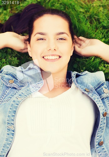 Image of smiling young girl lying on grass