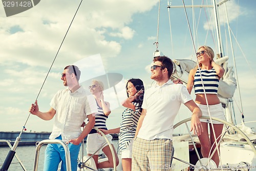 Image of smiling friends sailing on yacht