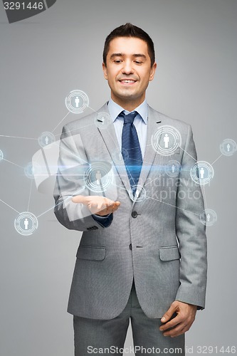 Image of happy businessman in suit showing network contacts