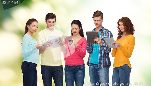 Image of group of teenagers with smartphones and tablet pc