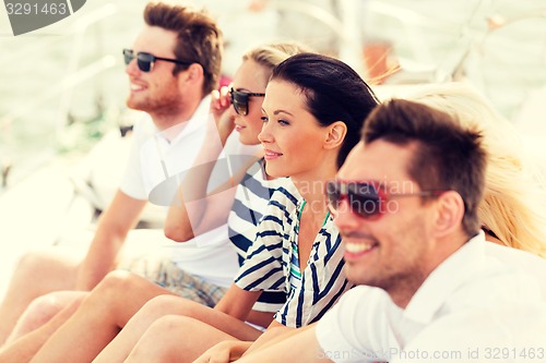 Image of smiling friends sitting on yacht deck