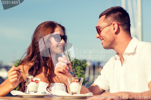 Image of smiling couple eating dessert at cafe