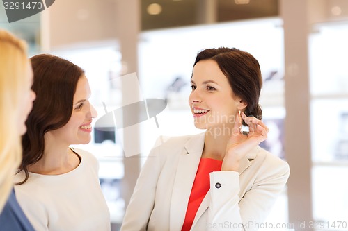 Image of happy women choosing earrings at jewelry store