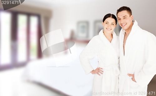 Image of happy couple in bathrobes over spa hotel room