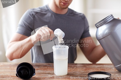 Image of close up of man with protein shake bottle and jar