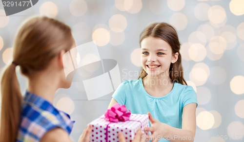 Image of happy girls with birthday present over lights